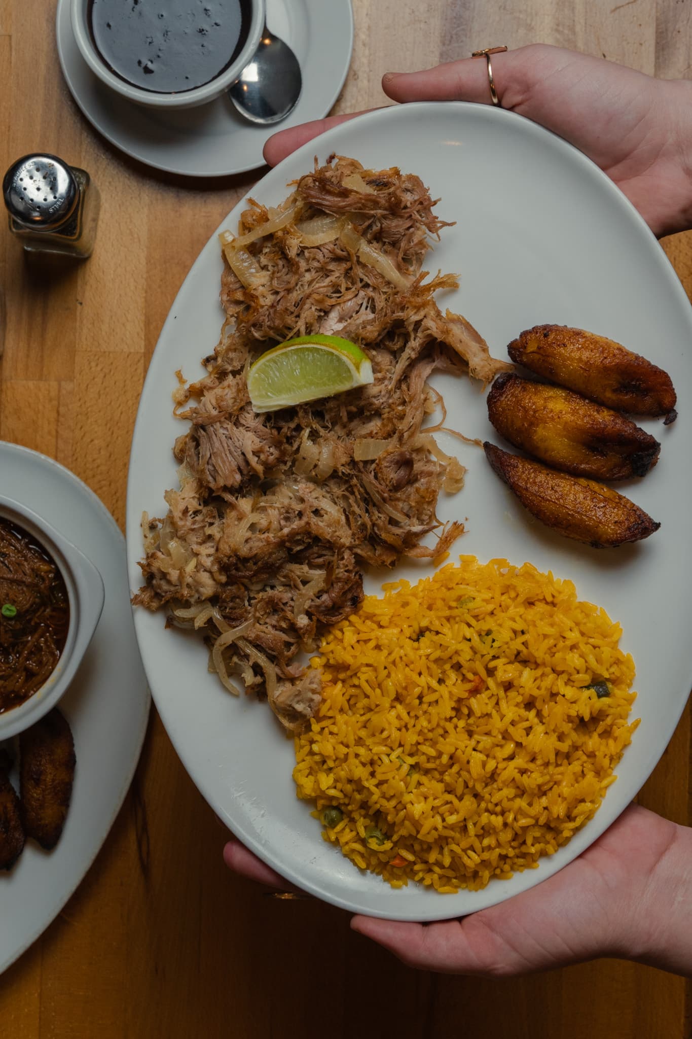 A platter of lechón asado with sweet plantains and yellow rice
