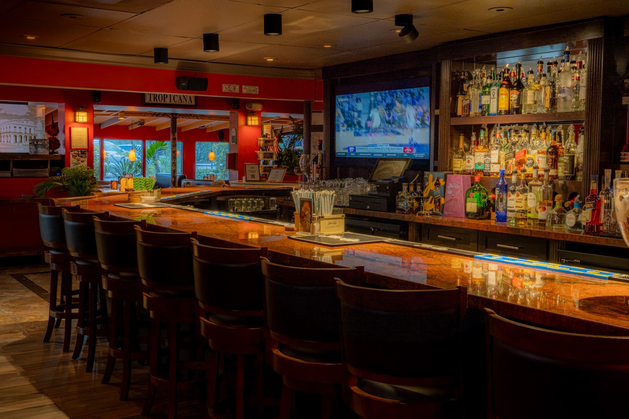 The full length of the bar beneath the lit liquor shelves